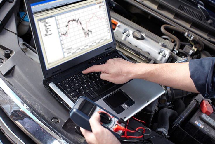 Technician performing engine diagnostics using advanced scan tools at Merrick Tire Center in Queens, NY